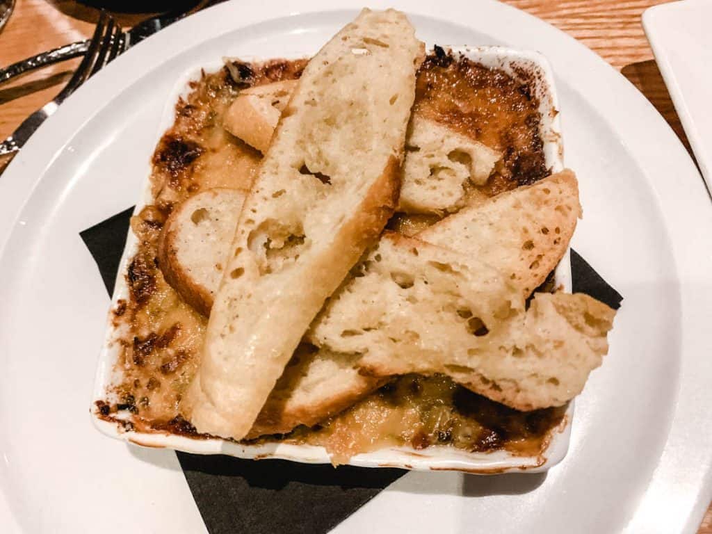 artichoke dip in a square dish with crostini