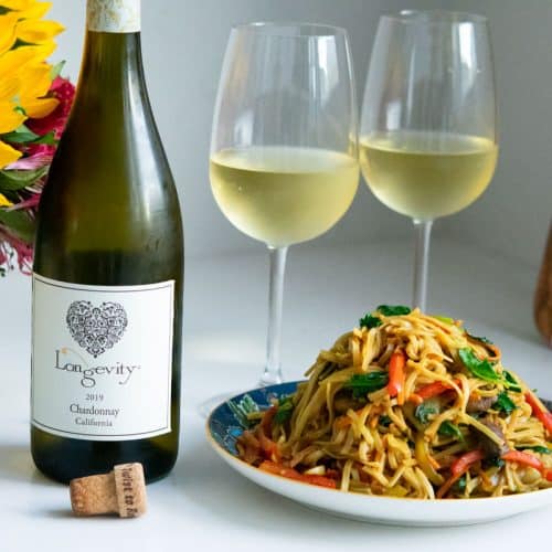 2 glasses of Longevity chardonnay with a plate of Singapore curry noodles