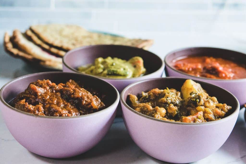 Goan curries in pink bowls