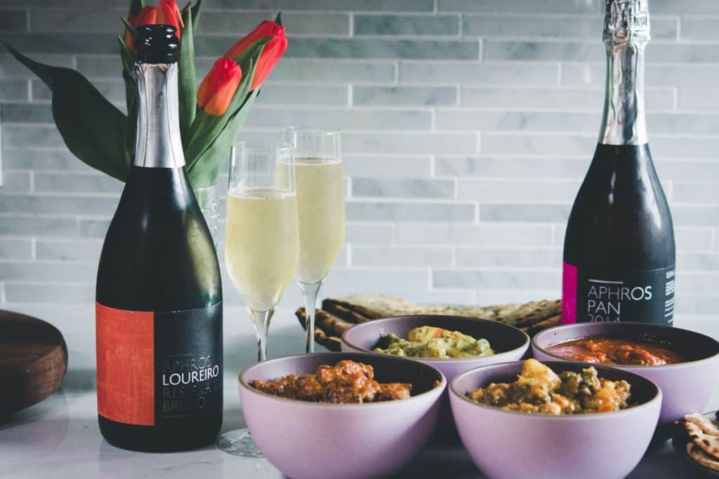 aphros sparkling wine with goan curries in pink bowls