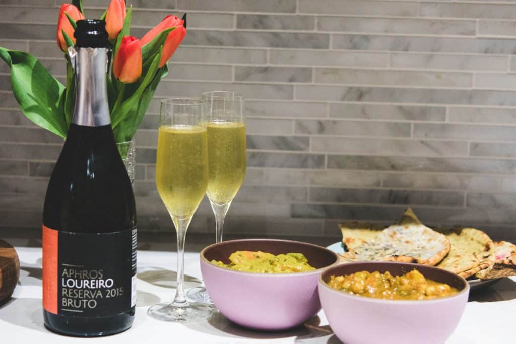 aphros loureiro sparkling wine with 2 vegan curries in pink bowls