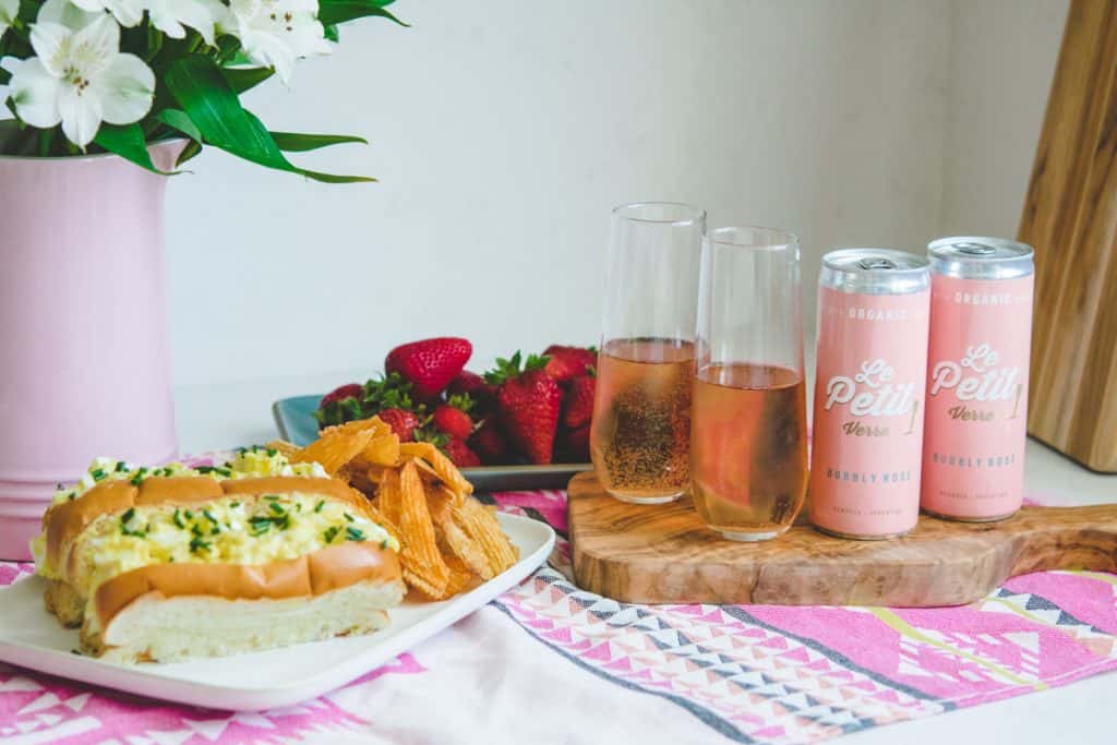 2 La Petit Verre cans of sparkling rose with 2 flutes and egg salad sandwiches