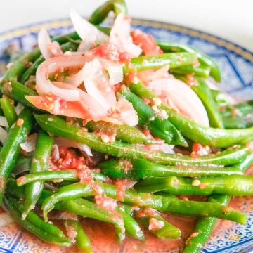 Ukranian green bean salad on a round blue plate