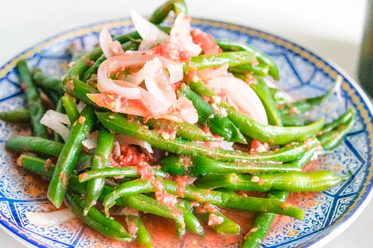 Ukranian green bean salad on a round blue plate