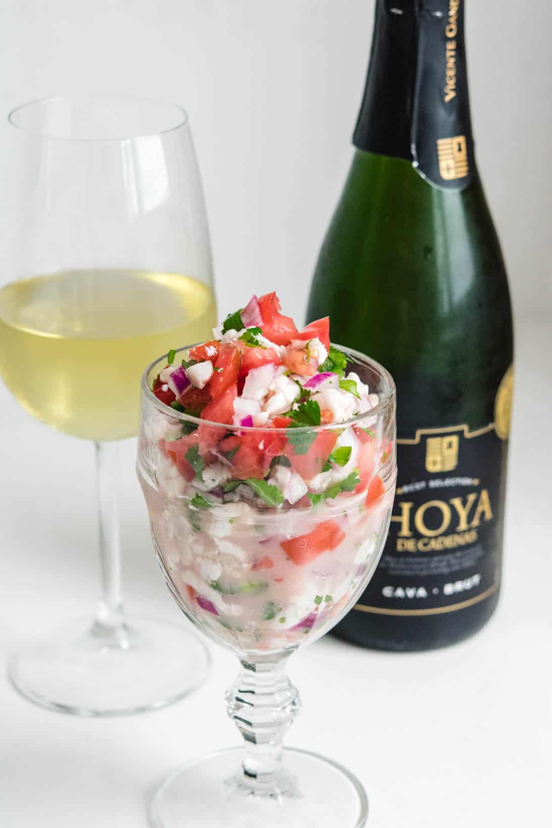 Ceviche in a goblet with a glass of Cava sparkling wine