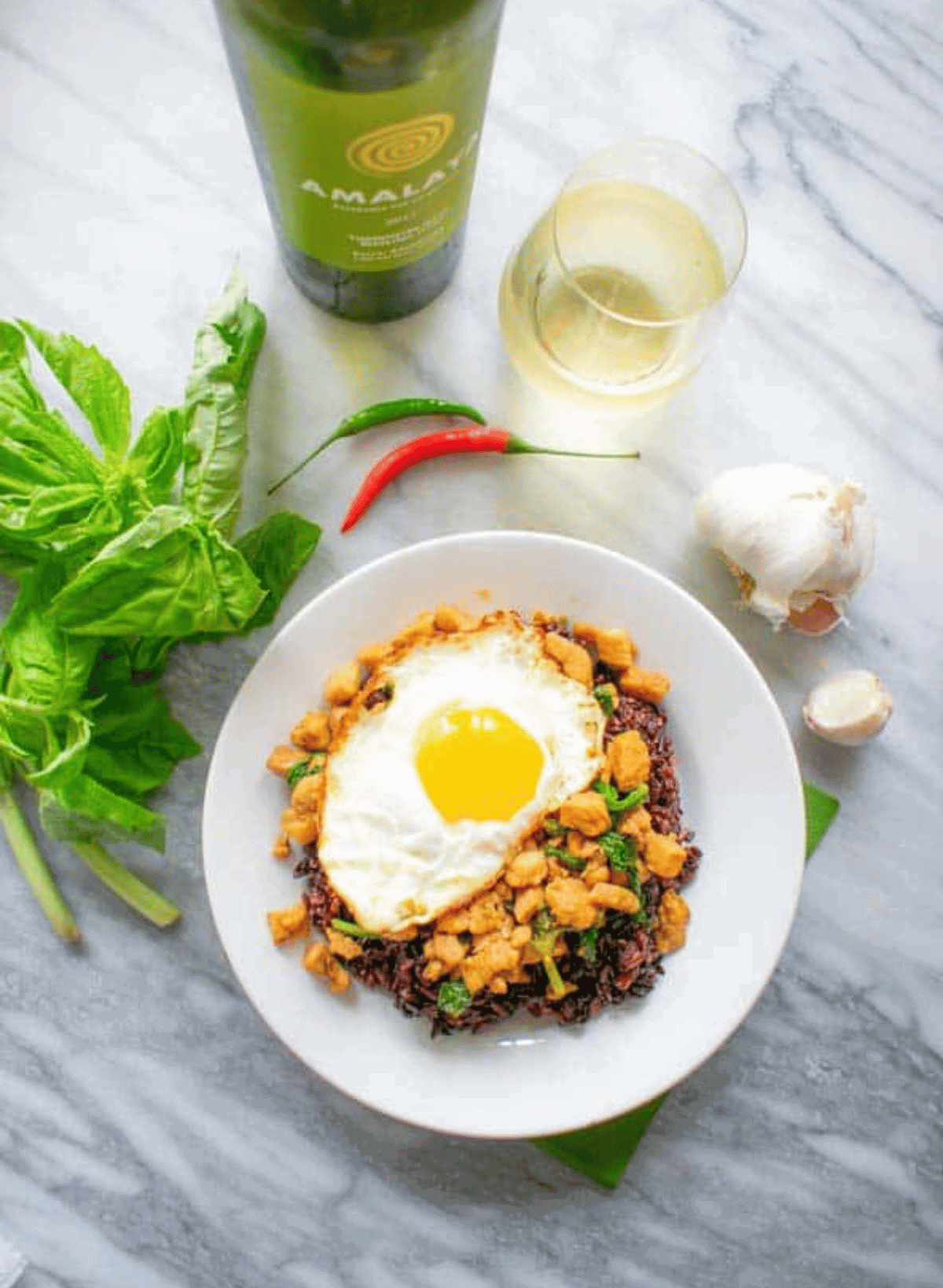 Thai Basil Chicken Pad Kra Paw on a white plate with fried egg