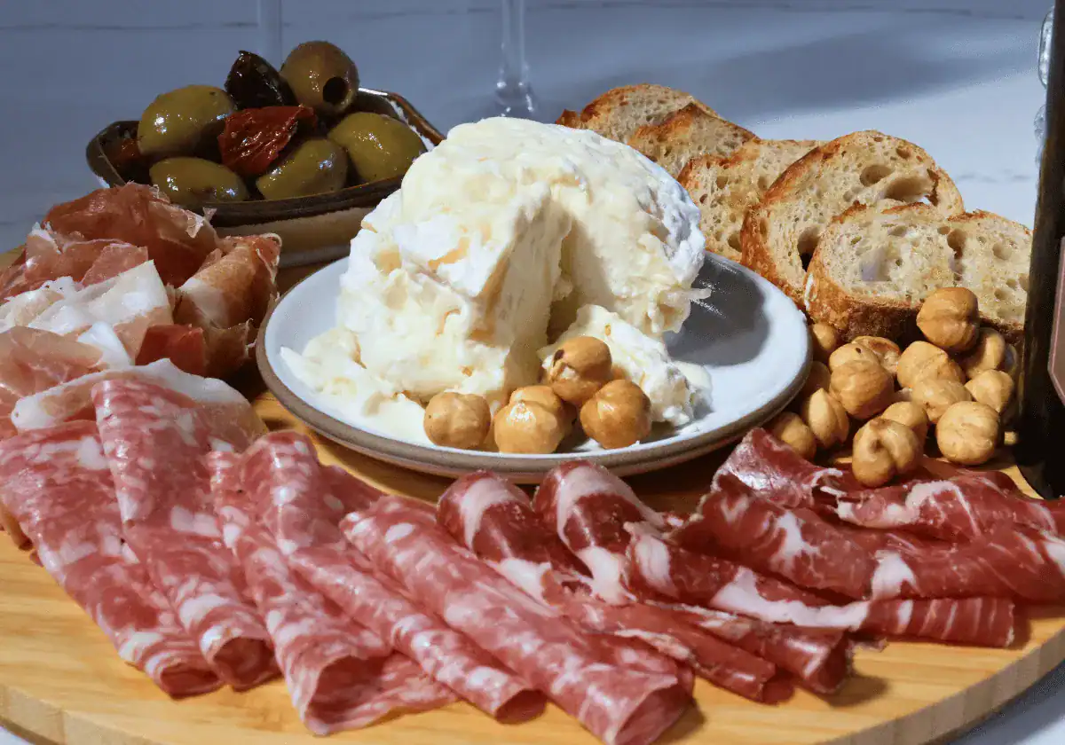 La Tur cheese round with a wedge taken out on a charcuterie board